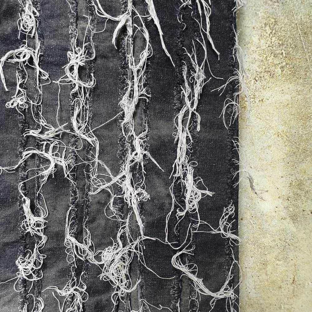 Black washed tie-dye denim fabric with horizontal stripes and fringed edges